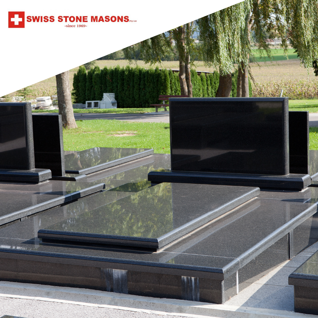 Well-maintained black granite tombstones in a peaceful cemetery setting, reflecting the importance of regular care and upkeep by Swiss Stone Masons.